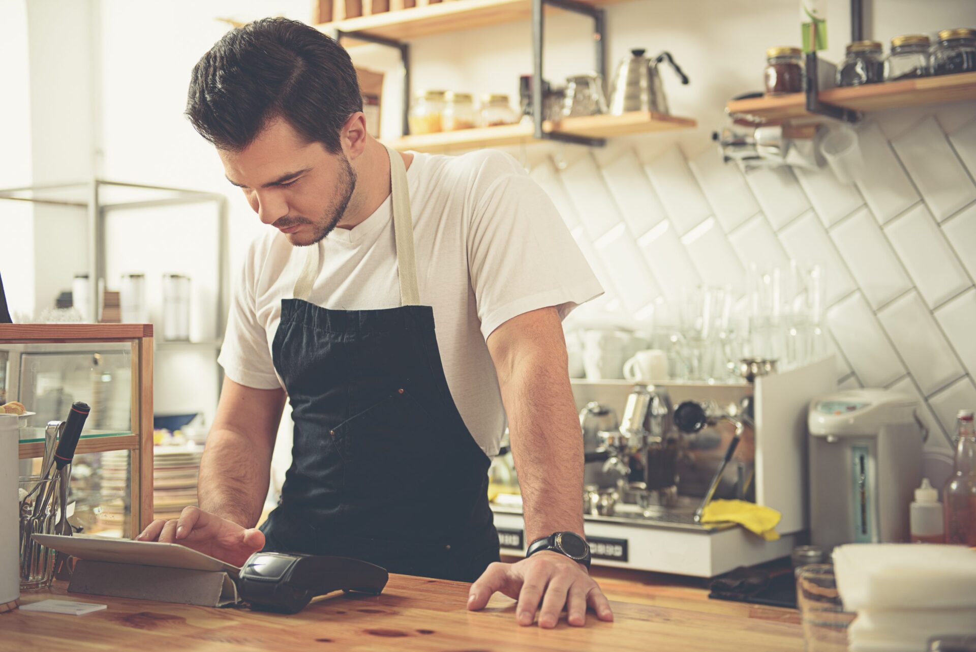 A male hospitality worker at the cash register